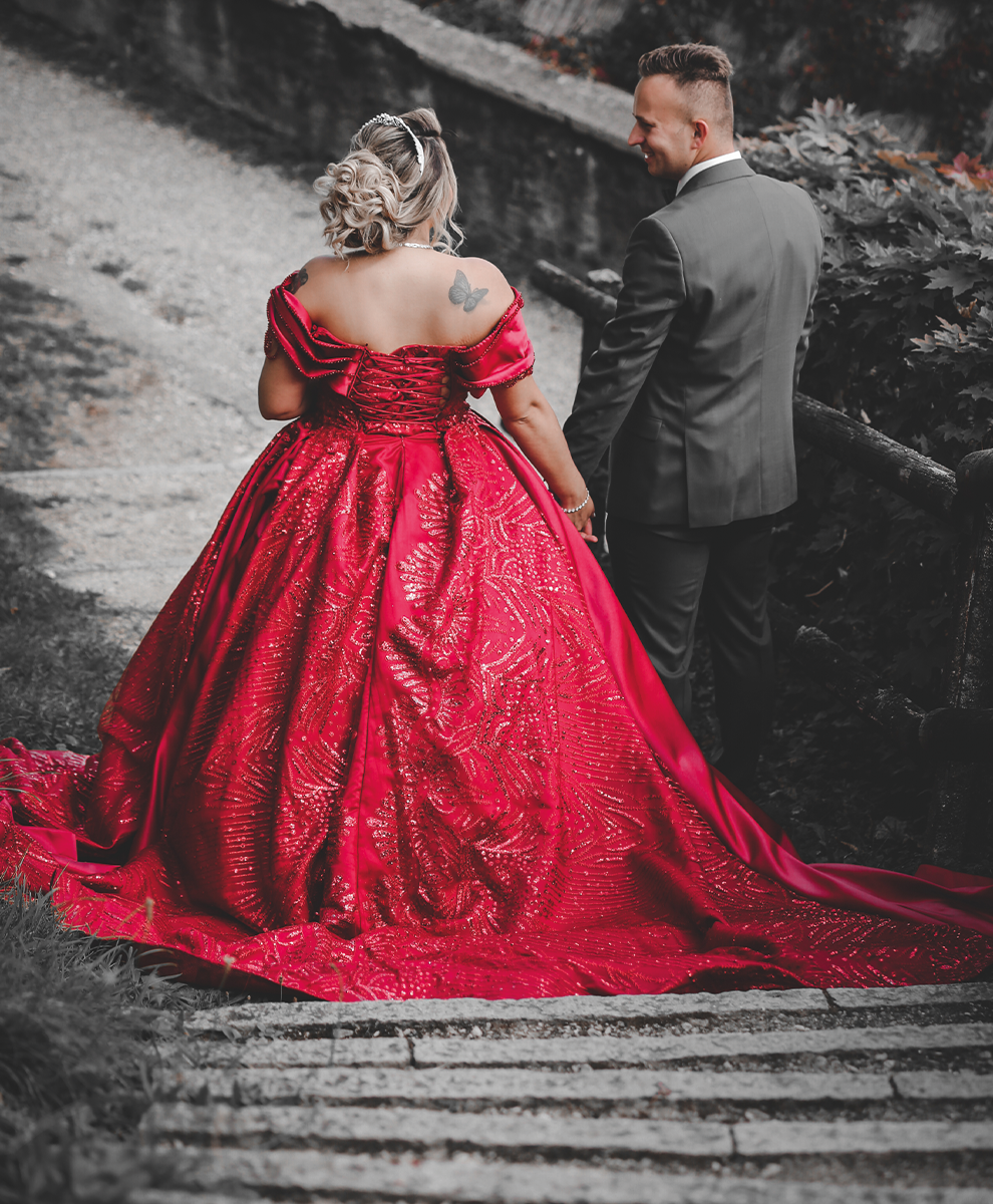 Brautpaar in festlicher Kleidung auf Steintreppe.